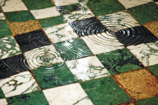 Rainwater creates ripples on a tiled floor in a cafe photo