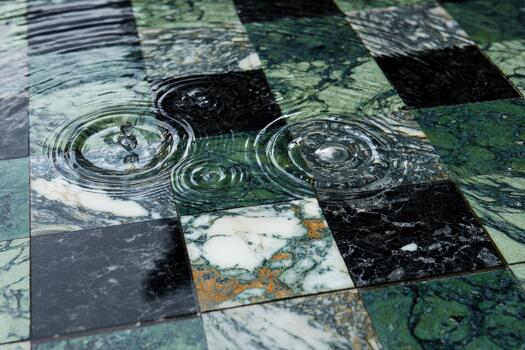 Rain creates ripples on a marble floor in a quiet space photo