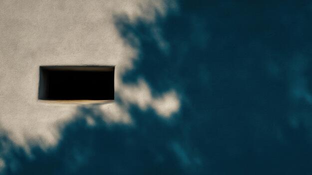 Shadows cast on a wall with a small opening at sunset photo