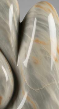 Close up abstract view of smooth polished stones with swirling gray and beige patterns creating a natural textured background photo