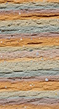Close up view of a stack of handmade paper sheets displaying a vibrant and textured layered pattern with earthy tones photo