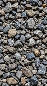 A close up view of a dense collection of varied sized and colored river stones creating a textured natural background pattern photo