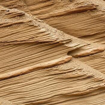 Close up view of textured sandstone layers displaying intricate patterns and natural erosion in warm earthy tones photo