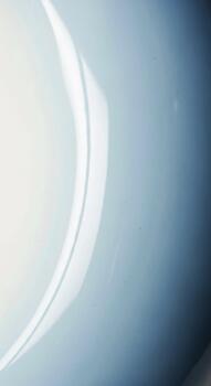 Abstract light and shadow play across a smooth curved surface with a textured background creating a sense of depth and mystery photo