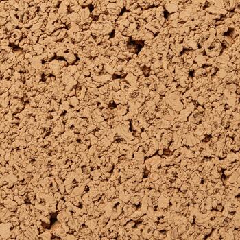 Close up view of a textured porous light brown concrete block surface with subtle variations in color and shadow photo