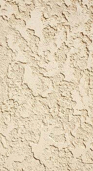 Close up textured stucco wall with rough irregular patterns and shadows creating depth and visual interest in a neutral beige tone photo