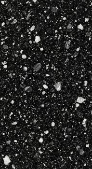 Close up view of a dark speckled surface with white and gray flecks creating a textured abstract pattern. photo