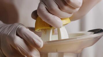 mani indossare guanti spremitura Limone con spremiagrumi estrazione succo nel un' cucina ambientazione Visualizza video