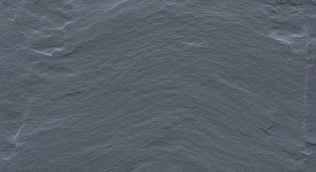 Close up textured surface of dark grey slate stone with rough irregular patterns and natural mineral variations photo