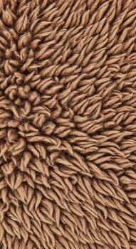 Close up textured abstract background of soft fuzzy brown fabric with a dense pile of fibers photo