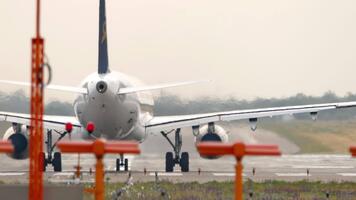 flygplan placerad på de bana redo för ta av, med navigering lampor lysande genom en dimmig, dimmig bakgrund atmosfär video