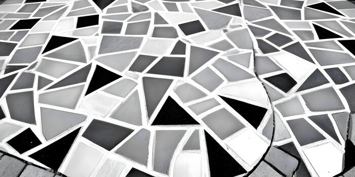 An abstract monochrome mosaic pattern composed of irregularly shaped black white and gray tiles creating a geometric texture photo