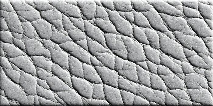 A close up view of a textured light gray leather like material showing an irregular diagonal quilted pattern photo