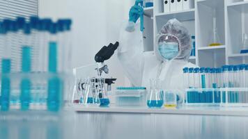 nel un' superiore laboratorio, un' qualificato scienziato nel un' protettivo completo da uomo conduce complesso esperimenti, gestione test tubi e analizzando campioni con precisione e intenso messa a fuoco, in mostra loro competenza video