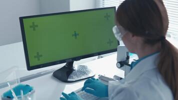 i en avancerad forskning anläggningen, en tillägnad forskare i en labb täcka användningar en komplex dator gränssnitt med en ljus grön skärm, highlighting modern vetenskaplig utforskning och innovation video