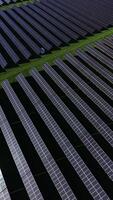 Vast array of solar panels generating clean energy in a green field under a bright blue sky video