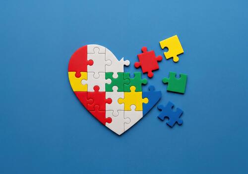 Heart Shaped Puzzle on Blue Background Symbolizing Autism Support and Understanding photo