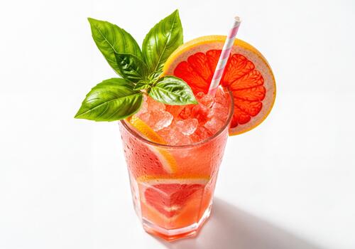 Refreshing Grapefruit and Basil Cocktail with Crushed Ice on a Clean White Studio Background photo