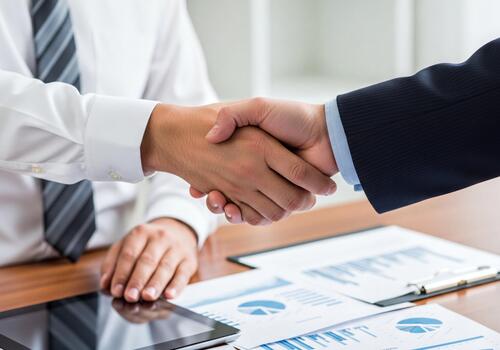 profesional apretón de manos sellando negocio camaradería acuerdo con financiero datos en mesa en oficina foto