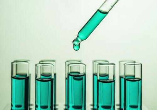 Laboratory Dropper Adding Green Liquid to Multiple Test Tubes in Scientific Research photo