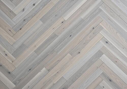 Light ash wood floor with elegant herringbone pattern showcasing natural textured grain background photo