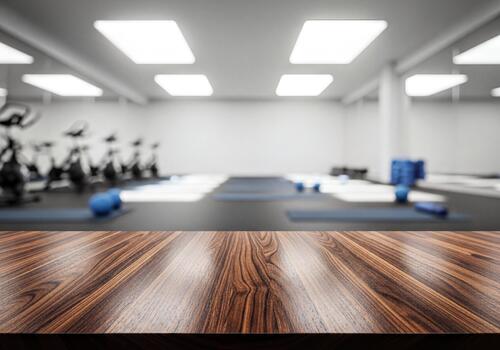 Empty Brown Wooden Table Top with Blurred Modern Fitness Studio Background for Product Display photo
