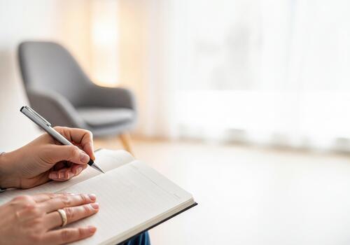 Professional hand writing notes in a clean white notebook with a pen photo