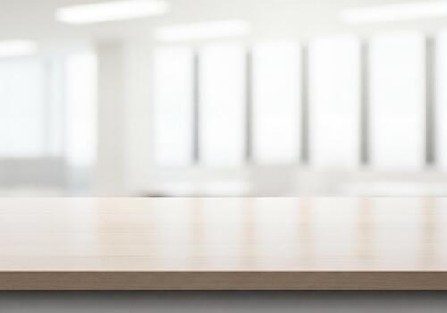 Empty wooden table surface with bright blurred office window background photo