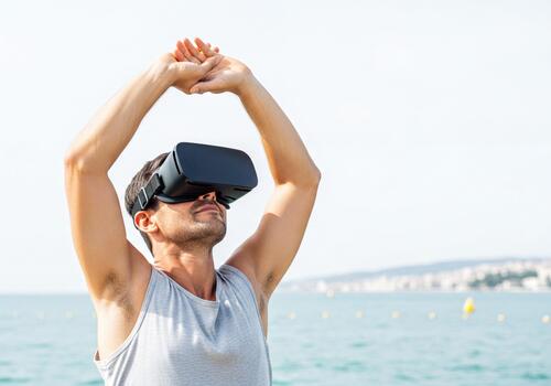 Man in VR Headset Stretching Outdoors Immersed in Virtual Experience by the Ocean photo