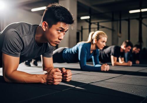 Determined Diverse Group Engages in Plank Exercise for Core Strength Training at Modern Gym photo