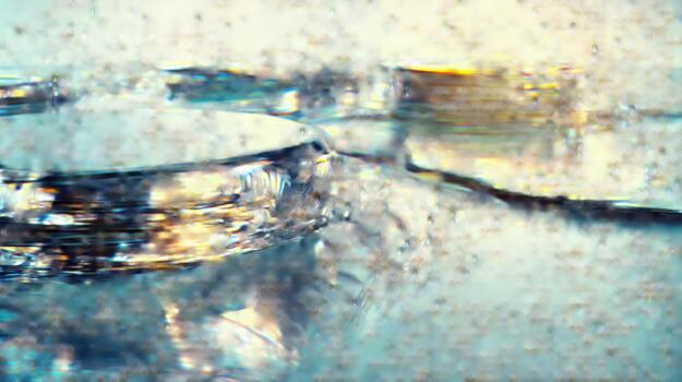 Abstract macro photography of ice crystals forming on water surface, shimmering light refractions., science photo