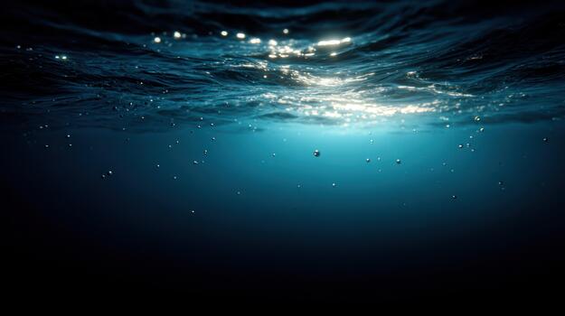 Underwater view of sunlit surface and dark ocean depths with clear water photo