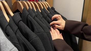 händer av en person välja annorlunda kläder från en garderob, highlighting olika texturer och mönster. video