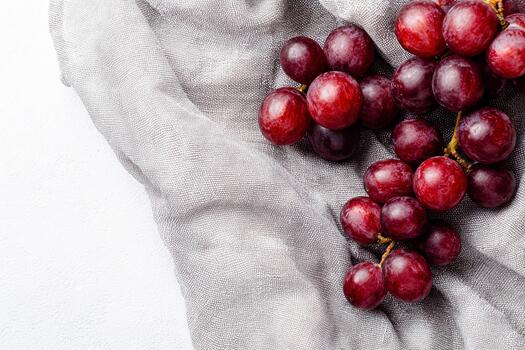 Grapes scattered on a linen cloth create a simple minimalist arrangement photo