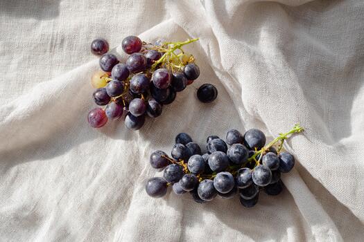Grapes scattered on a linen cloth create a minimalist aesthetic in natural light photo