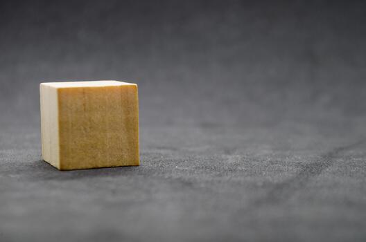 An isolated wooden cube on dark background with customizable space for text or ideas. Copy space concept.. photo