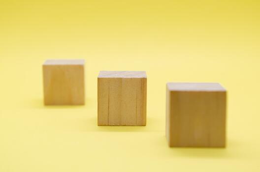 Close up view of isolated wooden cube with customizable space for text or ideas on yellow background photo