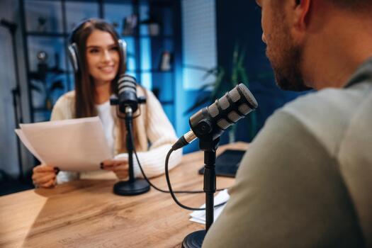 un hombre y mujer en un estudio hablando en un micrófono foto