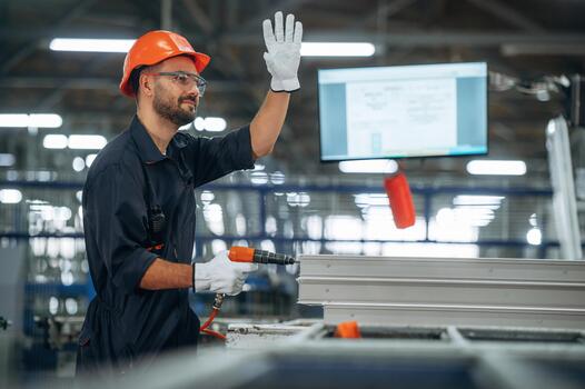 Worker with tool in manufacturing facility photo