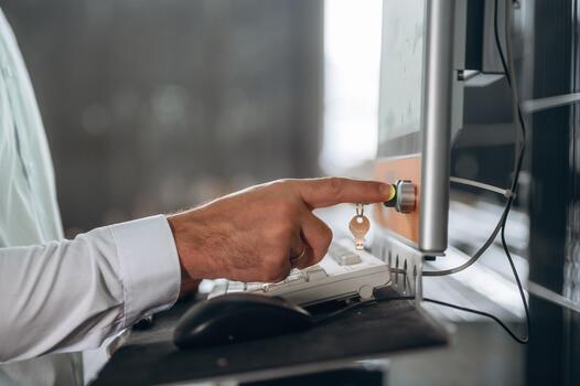 Hand pressing computer power button photo