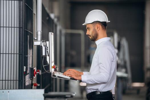 Engineer using computer in factory photo