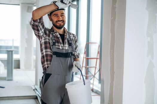 Worker with bucket and paint roller photo