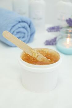 Concept with liquid yellow paste for shugaring on white background, space for text photo