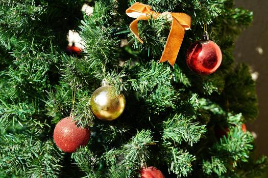 Close-up View of Christmas Tree with Colorful Ornaments and Bright Green Foliage Creating a Festive Holiday Atmosphere photo
