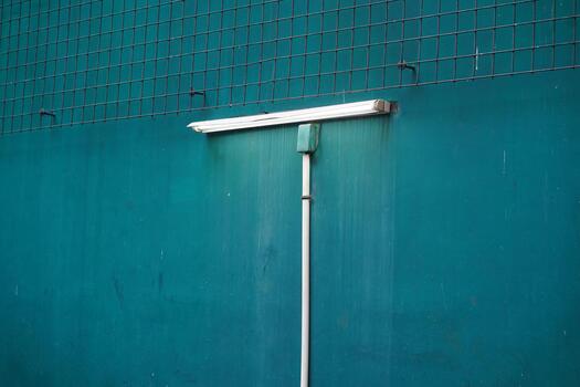 Minimalist Image of a Green Wall with Fluorescent Light Fixture and Water Dripping Effect Capturing Urban Aesthetics and Industrial Vibes photo