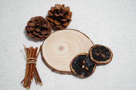 natural rústico decoración elementos presentando madera rebanada, pino conos, seco agrios rebanadas, y leña menuda en texturizado blanco antecedentes para estacional diseño proyectos foto