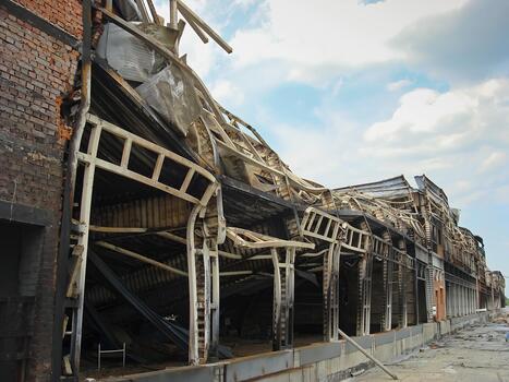 A warehouse with a loading ramp after a fire. Burnt metal frame of the building. Consequences of the fire photo
