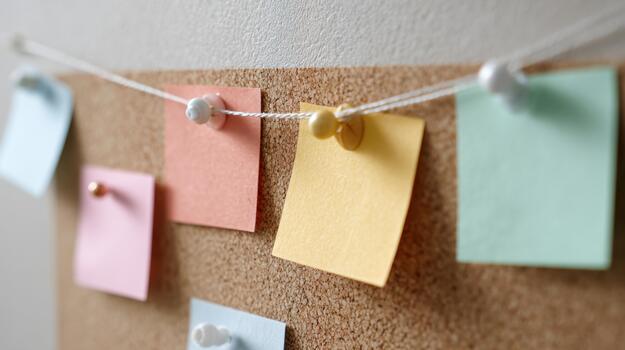 vistoso pegajoso notas colgando en un corcho tablero foto