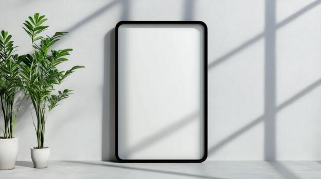 A white rectangular frame with a plant in front of it photo