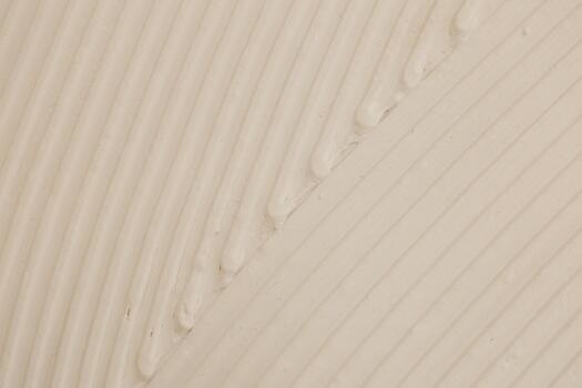 Smooth white surface with textured lines and droplets visible in soft light photo